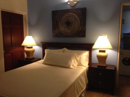 a bedroom with a bed with two lamps on tables at Villa Touloulou in English Harbour Town