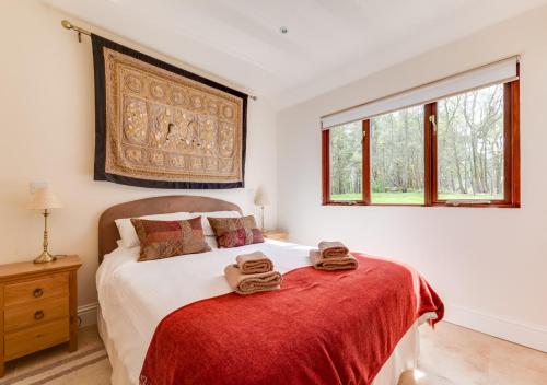 a bedroom with a bed with two towels on it at Sugarloaf Cottage in Brightling