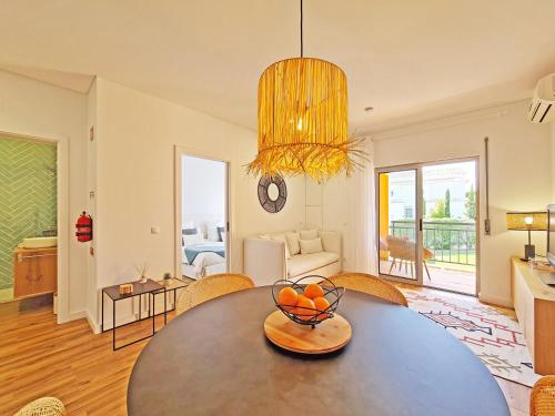 a living room with a table with a bowl of fruit on it at Apt MC - with pool in Alcantarilha