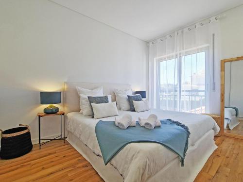 a bedroom with a large bed with two towels on it at Apt MC - with pool in Alcantarilha