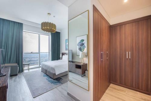 Habitación de hotel con cama y espejo en Golf Views in 30th Floor en Dubái