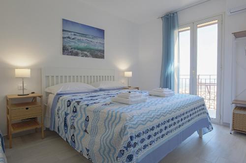 a bedroom with a bed with a blue and white blanket at Zeus Atabyrios 2 - Monolocale in Agrigento