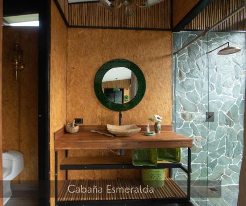 bagno con lavandino in legno e specchio di Magma "Eco Hotel Cabañas" a La Vega