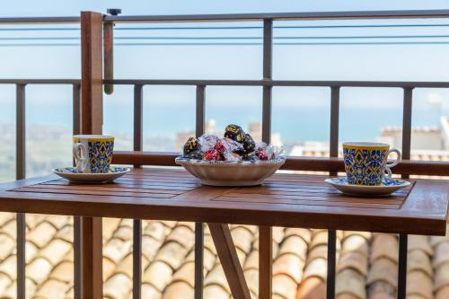 a wooden table with two cups and a bowl on it at Zeus Atabyrios 2 - Monolocale in Agrigento