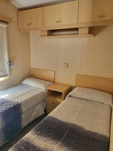a small room with two beds and a window at camping Pradon in Arnuero
