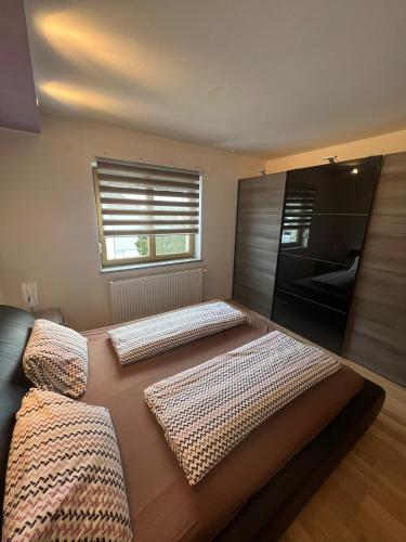 two beds in a room with a window at Terezia-Appartements Nassfeld in Hermagor