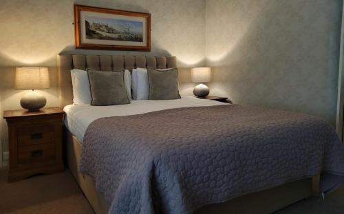 a bedroom with a large bed and two lamps at The Chequers Inn in Froggatt