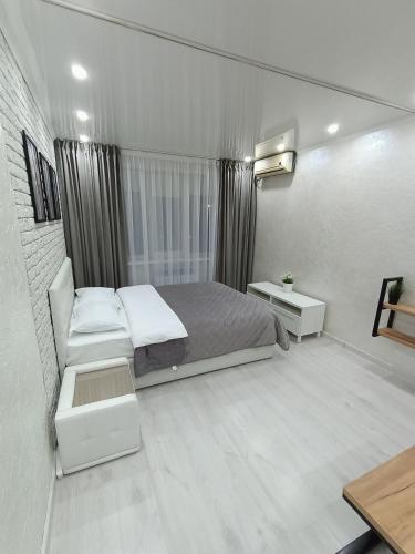 niewielka sypialnia z łóżkiem i oknem w obiekcie Дизайнерская квартира в центре города w mieście Pietropawłowsk Kamczacki