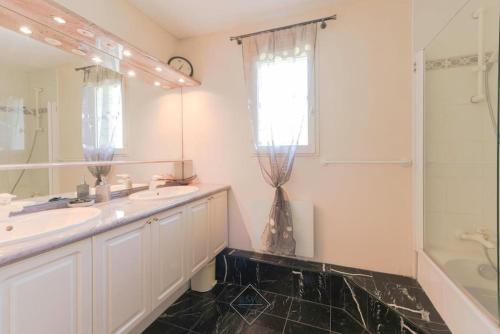 a bathroom with a sink and a shower and a mirror at Golf House Disneyland BMYGUEST in Bussy-Saint-Georges