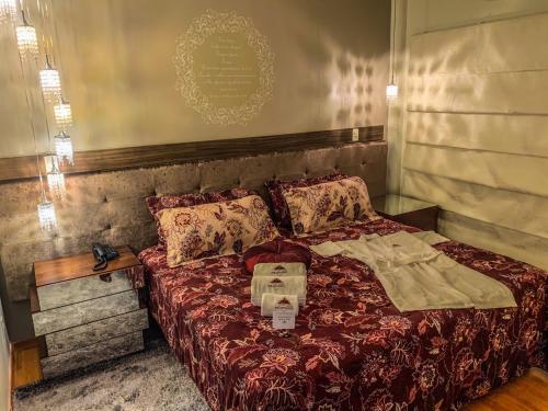 una camera con letto e piumone rosso di Hotel Piratininga Avenida Amazonas - Rondonópolis a Rondonópolis