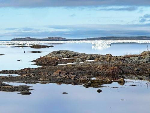 a large body of water with rocks and snow at Lucky Bay Hideaway - Seaview Sauna & cedar hot tub in Campbellton