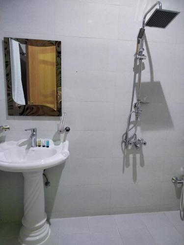a bathroom with a sink and a shower with a mirror at شقق هدوء الليالي للشقق المخدومة in Khamis Mushayt