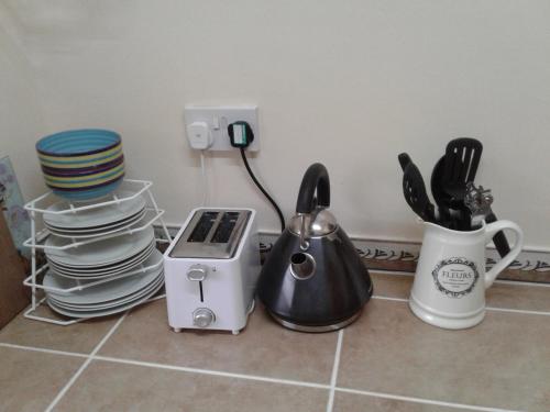 a kitchen counter with dishes and a toaster and plates at Trois Piton Apartments in Pont Cassé