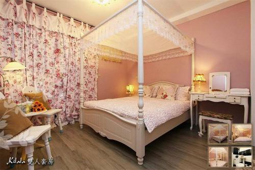 a girls bedroom with a canopy bed and a table at Gloria House in Hualien City