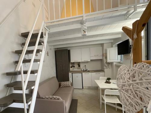 a living room and kitchen with a staircase in a room at Casa iuserì in Cisternino