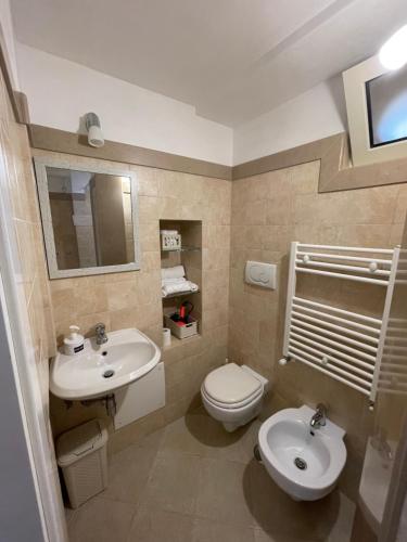a bathroom with two sinks and a toilet and a mirror at Casa iuserì in Cisternino