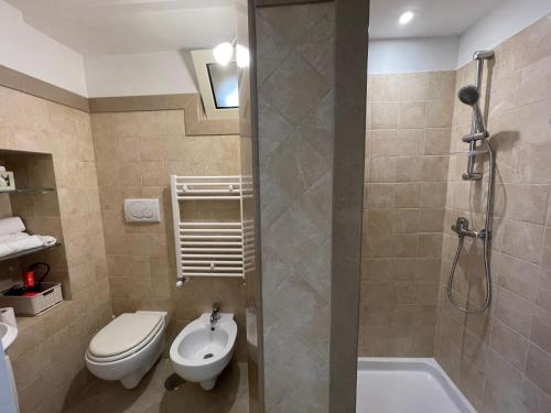 a bathroom with a shower and a toilet and a sink at Casa iuserì in Cisternino