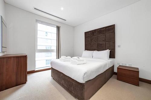 a bedroom with a large bed and a large window at 2 BR 2BTH apt near Battersea Power Station in London
