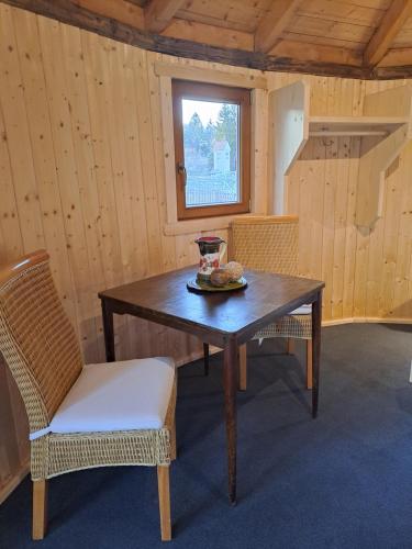 a table and chairs in a room with a window at Holzjurten by JULKA - self checkin in Finkenstein