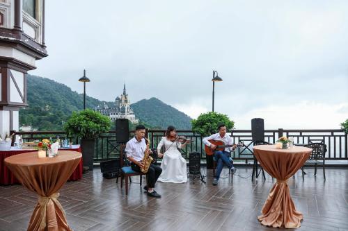 a group of people sitting on a balcony with music at Venus Hotel Tam Đảo in Tam Ðảo
