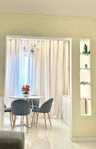 uma sala de jantar com uma mesa e cadeiras e uma janela em Ap Penélope charmosa em Teresina