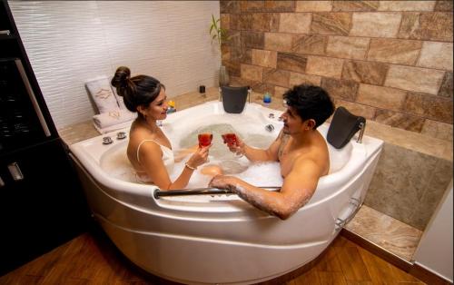 a man and woman sitting in a tub with wine glasses at MELTHON URBANS in Ayacucho