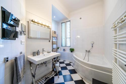 ein weißes Badezimmer mit einem Waschbecken, einer Badewanne und einem Waschbecken in der Unterkunft Frontière Monaco, Centre-Ville, Balconnet Vue Mer in Beausoleil