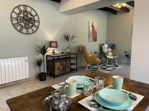 - une salle à manger avec une table et des assiettes dans l'établissement Le Cottage at The Moulin Treillard, à Saint-Hilaire-La-Treille
