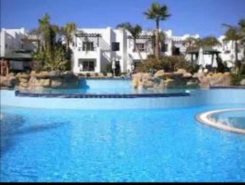 una gran piscina de agua azul con edificios al fondo en Flat for rent, en Sharm El Sheikh