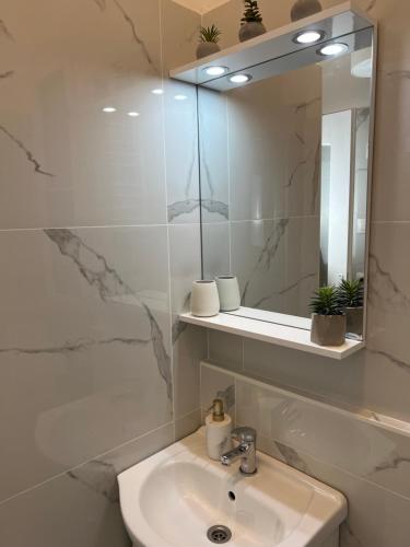 ein weißes Badezimmer mit einem Waschbecken und einem Spiegel in der Unterkunft New York Palace 2th apartment in the downtown in Budapest