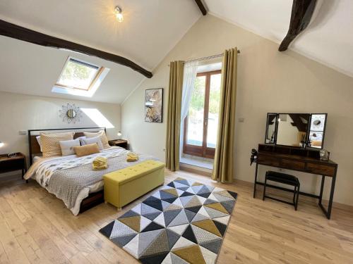 een slaapkamer met een bed, een tafel en een spiegel bij Le Cottage at The Moulin Treillard 