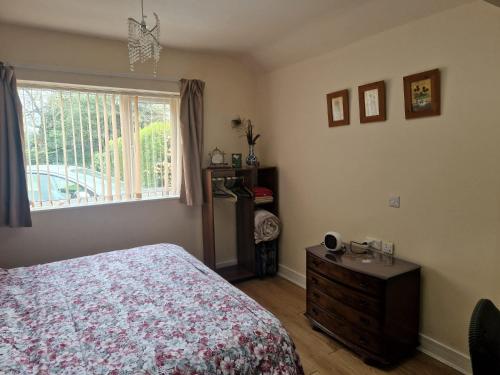a bedroom with a bed and a window and a dresser at Beautiful 1-Bed studio Lickey Hills Birmingham in Birmingham