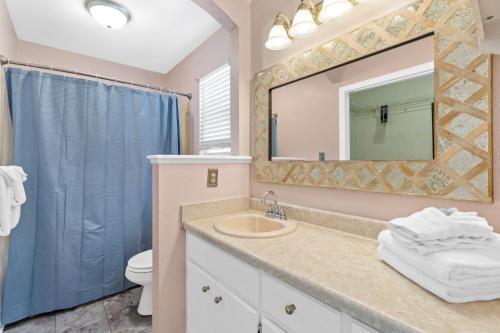 a bathroom with a sink and a mirror and a toilet at Beach House - Moasis by Panhandle Getaways in Panama City Beach