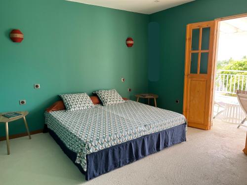a bedroom with a bed and a blue wall at Caraibe Créol' Keys in Port-Louis