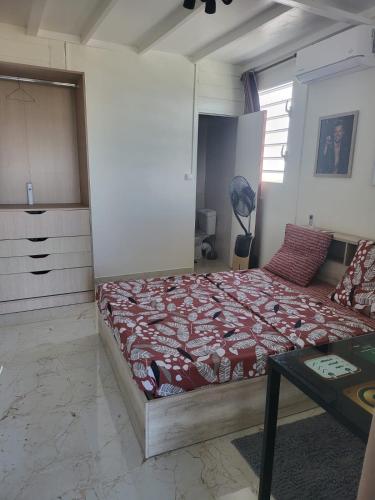 Un dormitorio con una cama y una mesa. en Petit paradis location en Le Vauclin