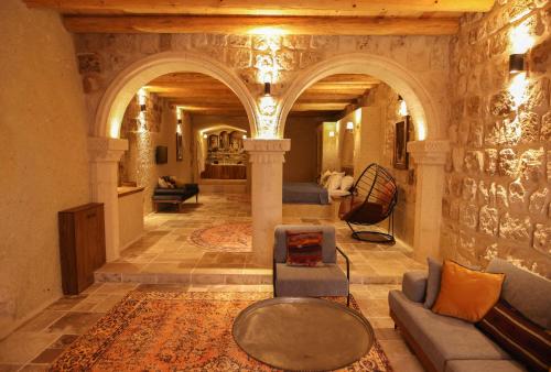Vita Cave Suites في أوروغوب: غرفة معيشة مع أريكة وطاولة