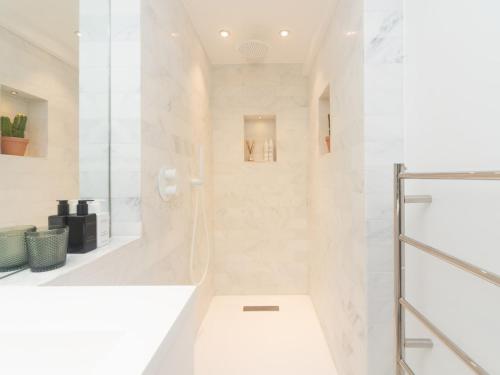 a white bathroom with a shower and a toilet at Modern Luxury 1 Bedroom Spacious Flat in London