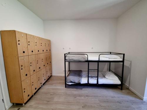 a room with a bunk bed and a room with lockers at Azulrelax Hostel in Pinhal Novo