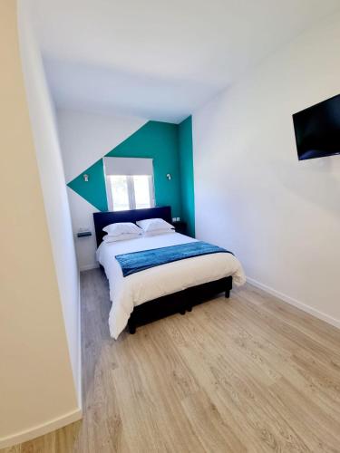 a bedroom with a bed with a green accent wall at Azulrelax Hostel in Pinhal Novo