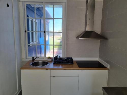 cocina con fregadero y ventana en Azulrelax Hostel, en Pinhal Novo
