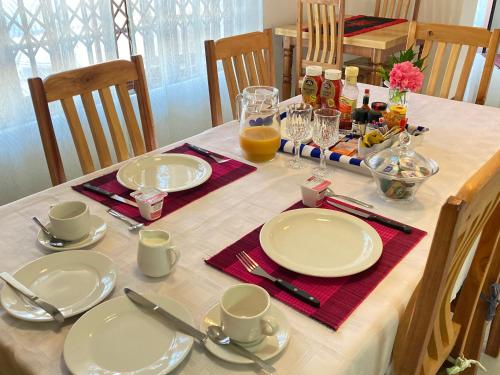a table with white plates and cups and drinks on it at Wildsands Bed & Breakfast in Wilderness