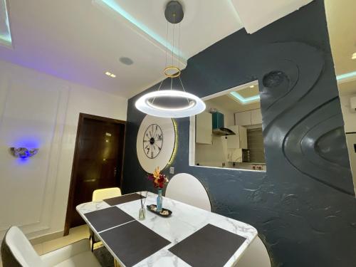 a dining room with a table and a clock on the wall at Magnificent 3-Bedroom in VI in Lagos