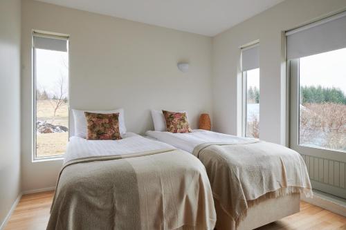2 camas en una habitación blanca con ventanas en Solheimar Eco-Village Guesthouse en Sólheimar