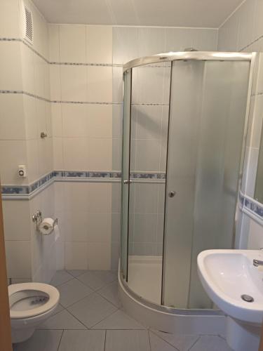 a bathroom with a shower and a toilet and a sink at Apartament do wynajęcia in Olecko