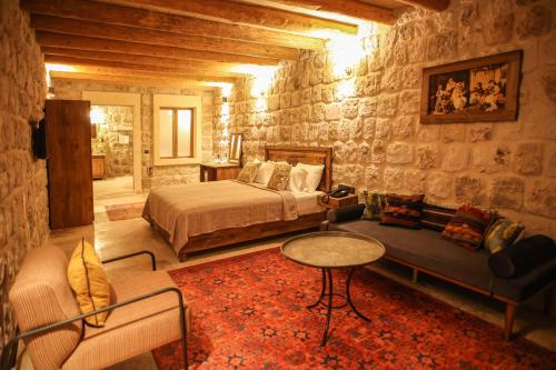 a bedroom with a bed and a couch and a table at Cappadocia Vita Cave Hotel in Urgup