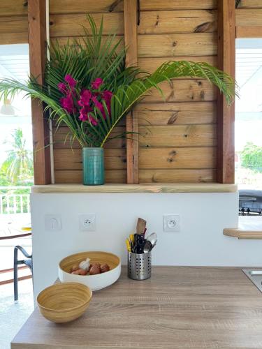 a kitchen counter with a bowl of food and flowers at Caraibe Créol' Keys in Port-Louis