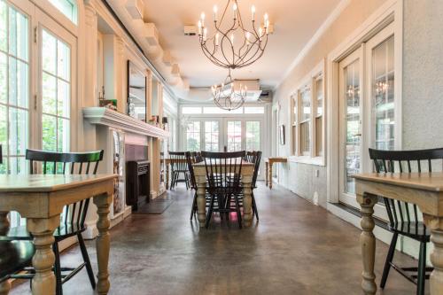 a dining room with tables and chairs and a chandelier at William Rockhill Nelson at Southmoreland on the Plaza in Kansas City