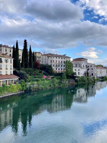 a river in a city with buildings in the background at T-Rooms in Bassano del Grappa