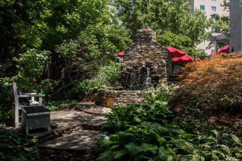 a stone fountain in the middle of a garden at Kathryn Winstead at Southmoreland on the Plaza in Kansas City