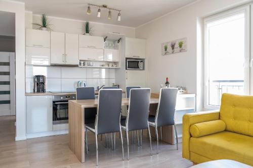 a kitchen and living room with a table and chairs at Apartament SŁONECZKO Rezydencja Ustronie Morskie in Ustronie Morskie